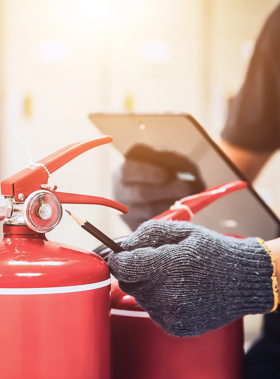 Agent de sécurité incendie en train d'inspecter des extincteurs